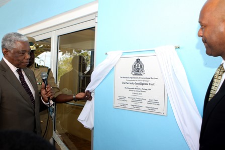 The Hon. Dr. Bernard J. Nottage unveils the plaque commemorating the dedication of the facility that will house the new CIU on the grounds of the Department of Corrections, January 19.  Minister of State for National Security, Senator Keith Bell is at right. (BIS Photo/Patrick Hanna)